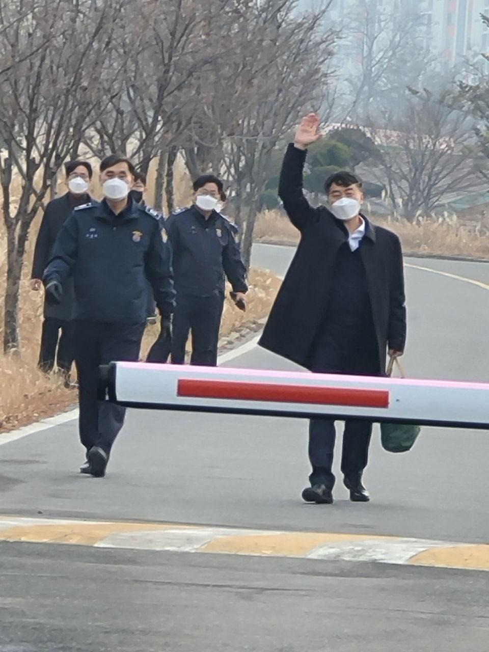 Lee being released, raising his arm in greeting
